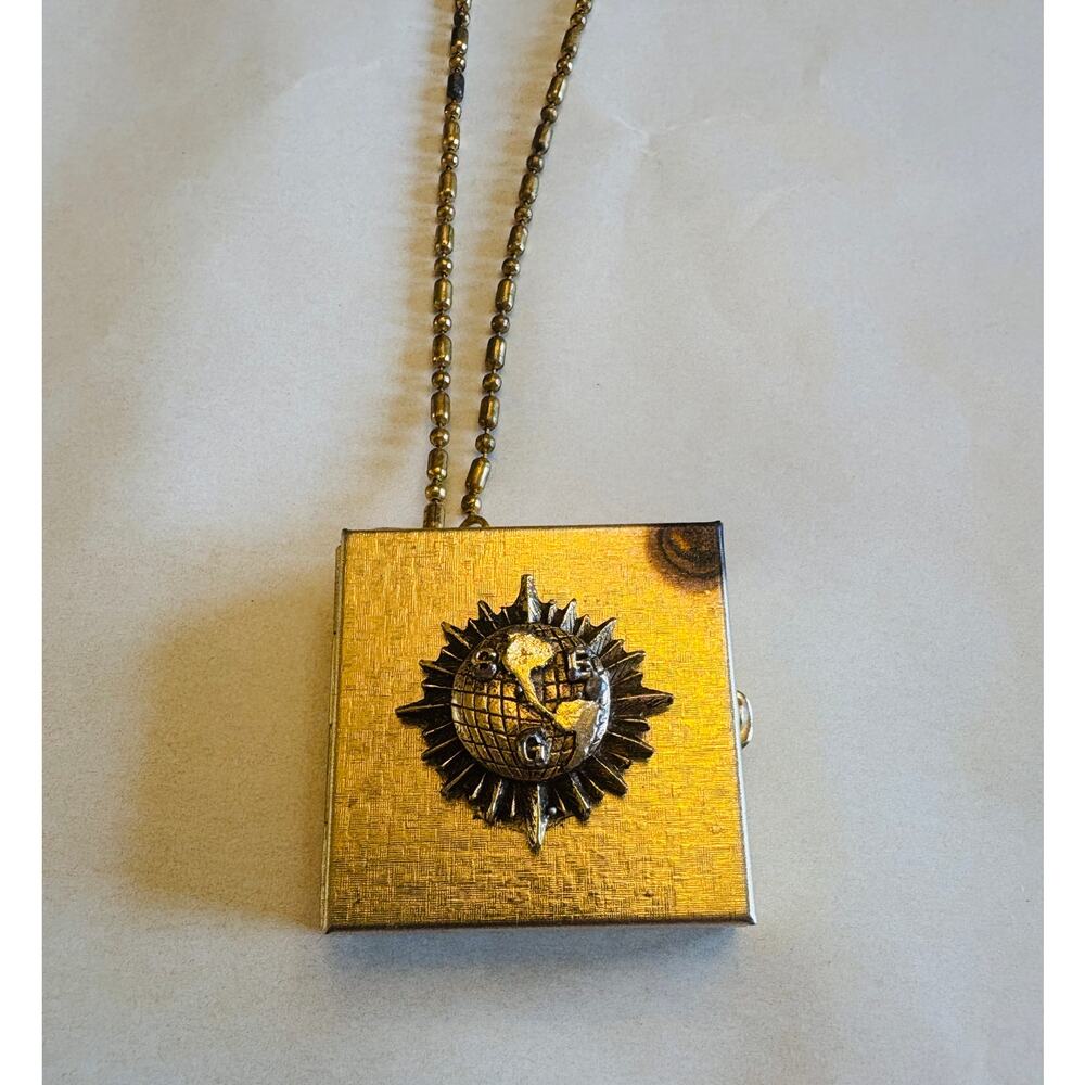 Vintage gold-toned square locket necklace featuring a sun motif on the cover